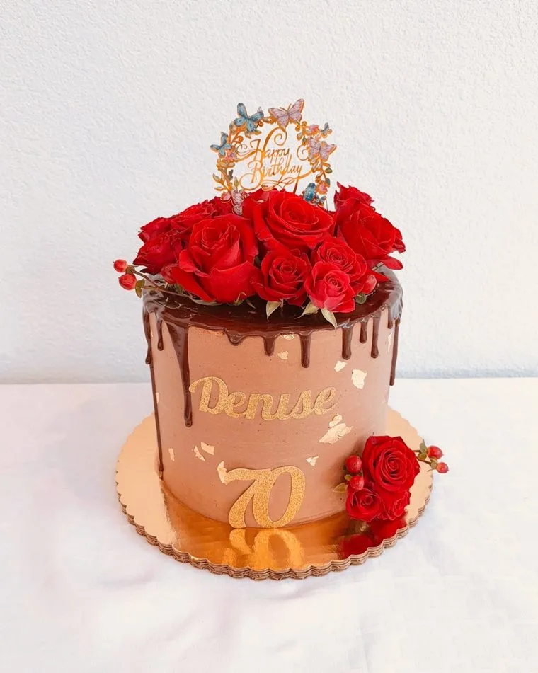 Chocolate drip cake crowned with fresh red roses