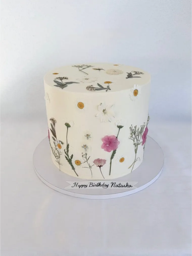 Cream cake decorated with pressed wild flowers